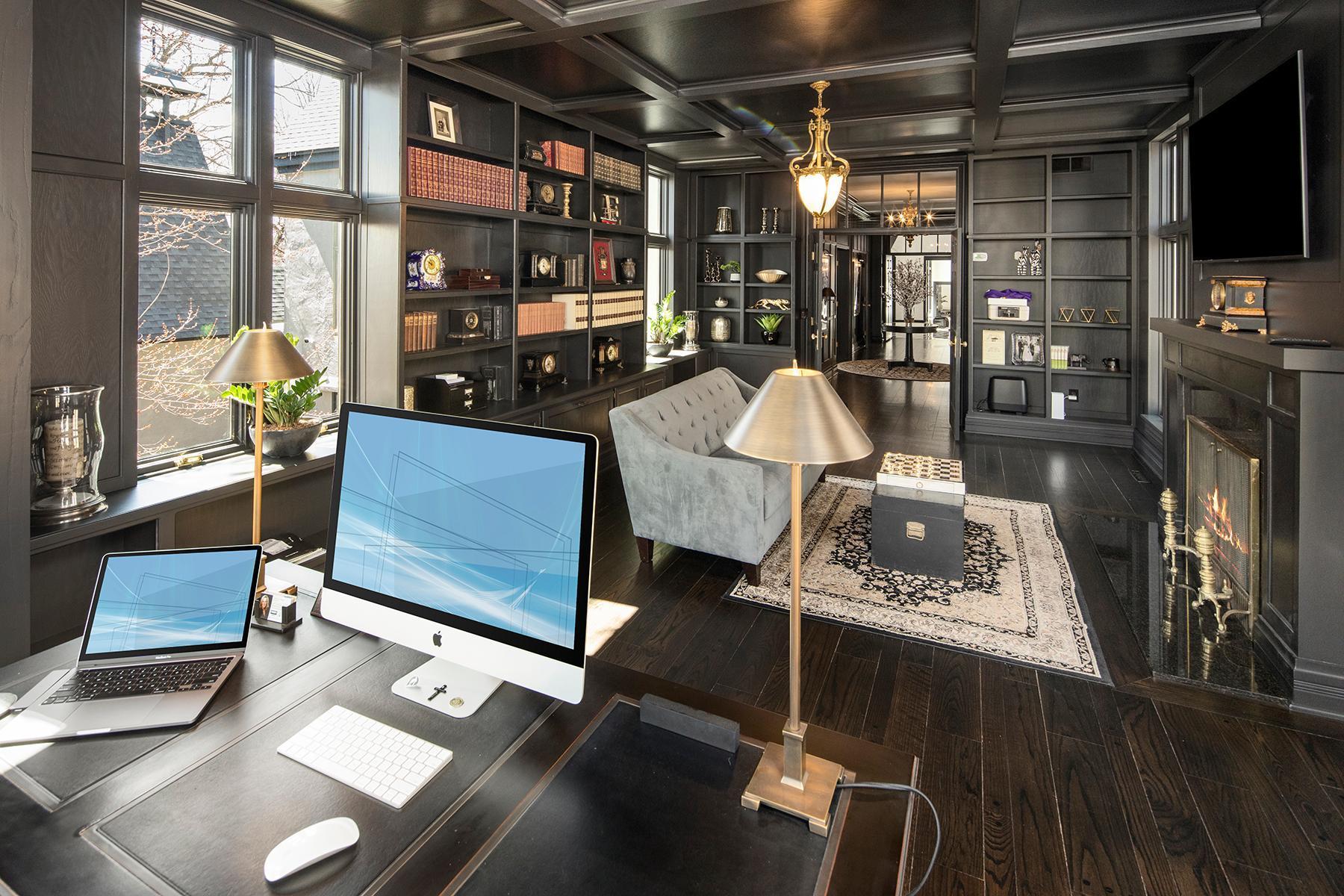 Impressive office has coffered ceilings, hardwood floors, fireplace and hidden nook behind the bookcase.