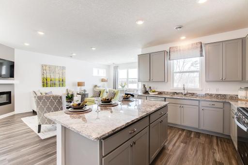 Open-and inviting, the home's living spaces flow seamlessly out from the kitchen - a theme consistent throughout the entire layout!! Pictures are of the decorated model.
