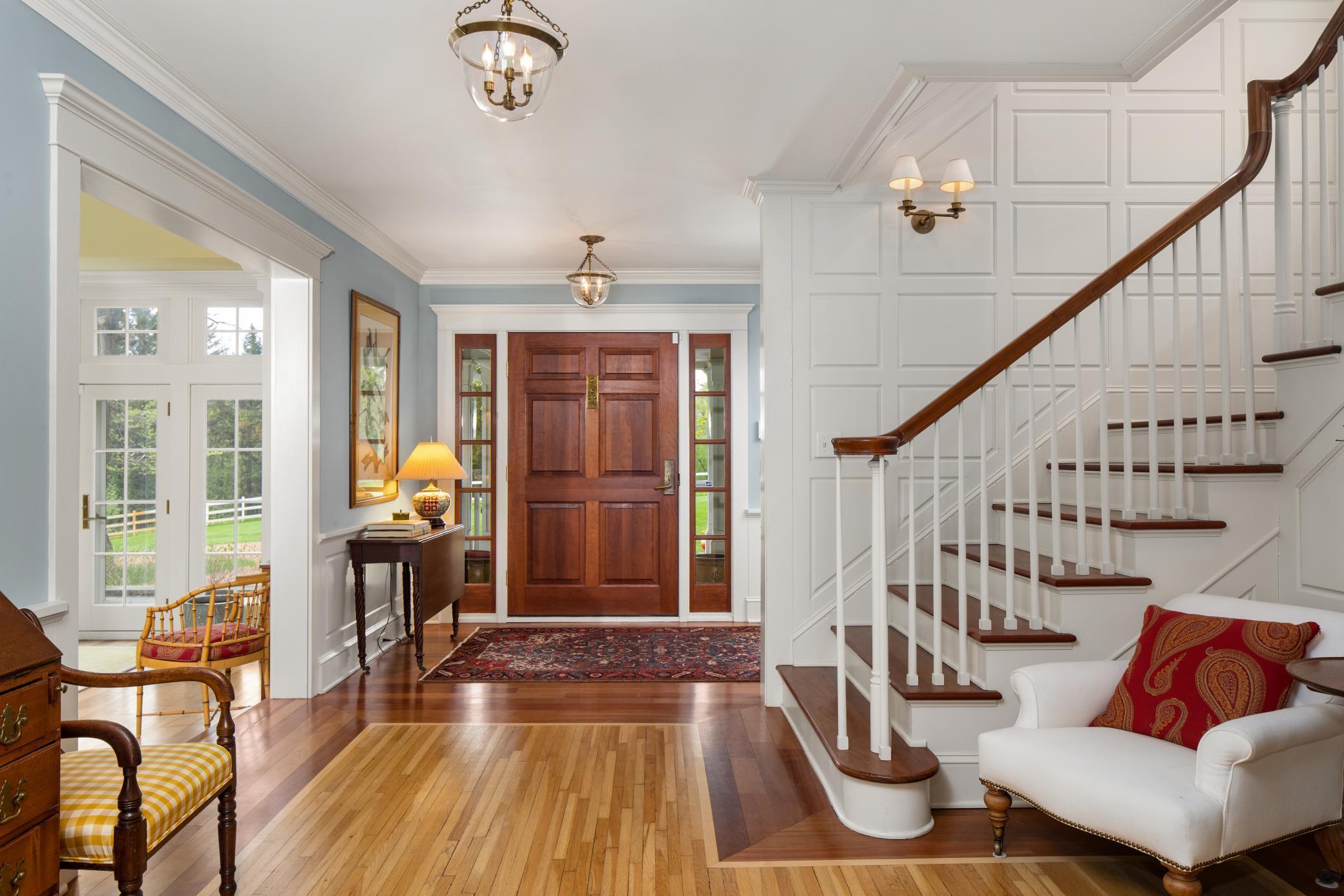 Gorgeous and spacious front entry greets you with original hardwood floors, paneled walls, wainscoting, grand staircase, and historically accurate fixtures.