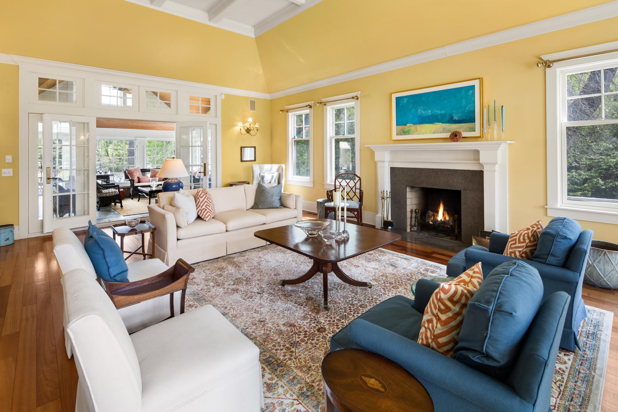 Formal living room with coffered ceilings, wood burning fireplace, and access to sunroom.