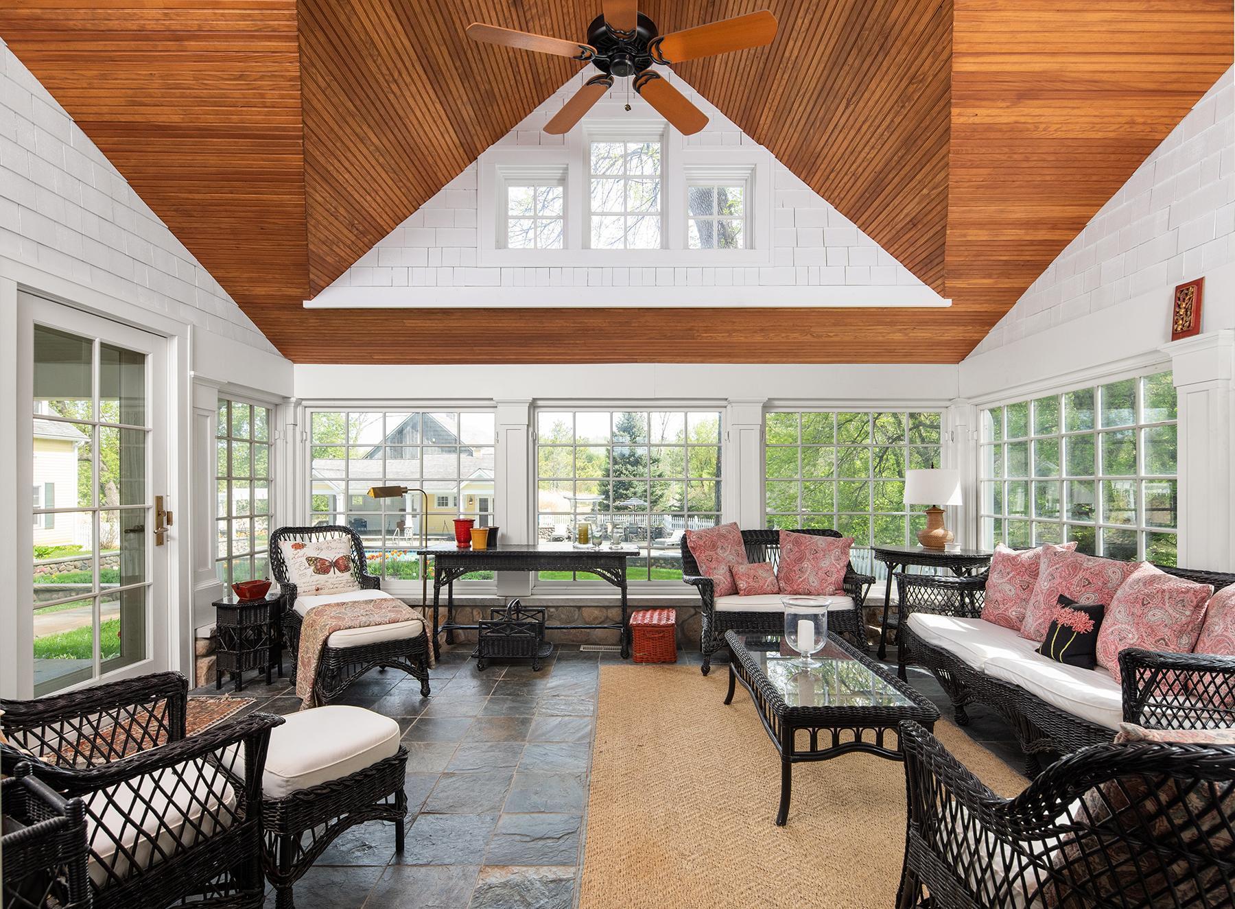 Beautiful four-season porch with vaulted beadboard ceiling, heated floors, and captivating views of the courtyard with pool and spa.