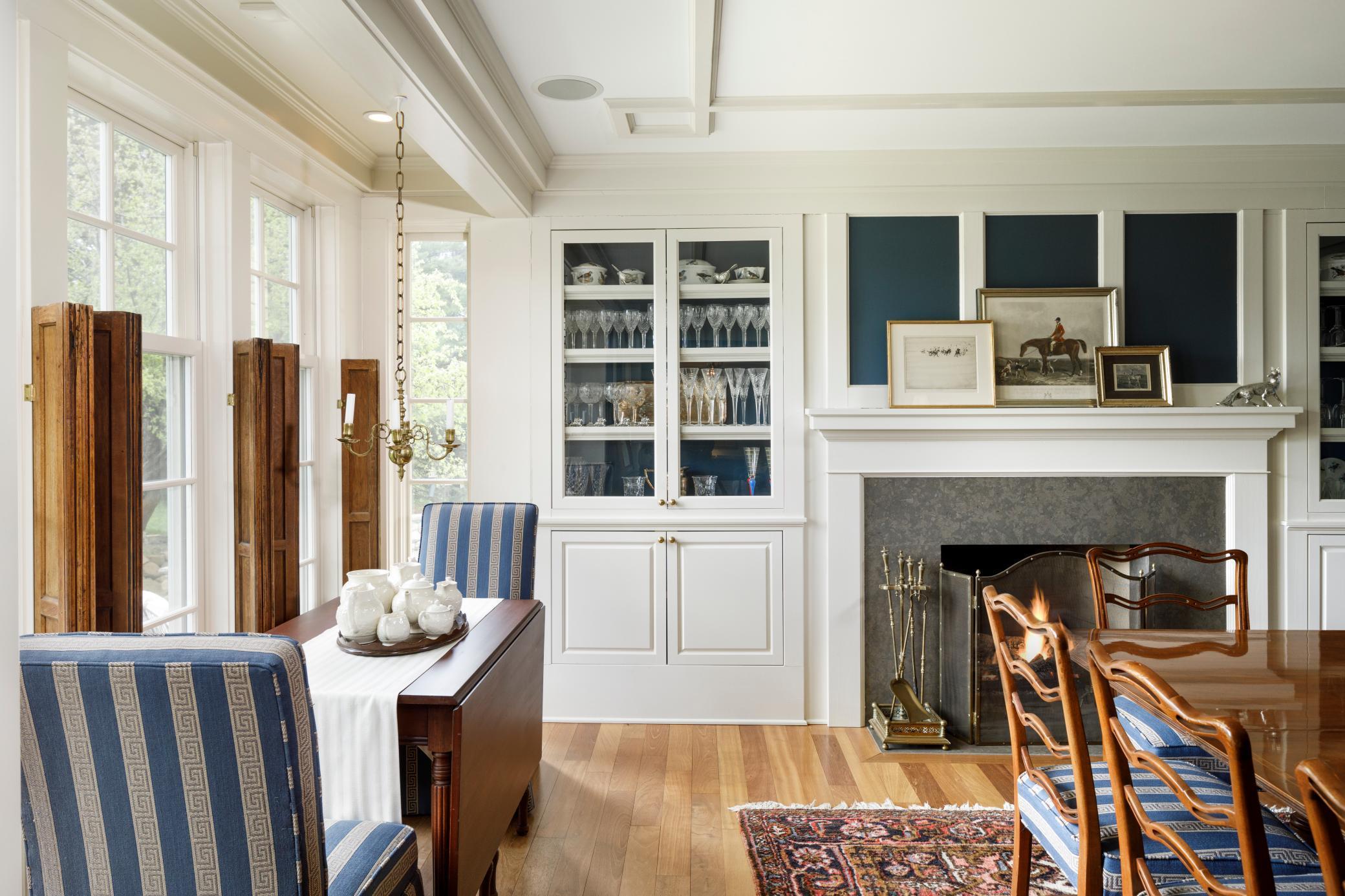 Formal dining room with built ins, box bay window, soapstone surround wood burning fireplace, and hardwood floors.