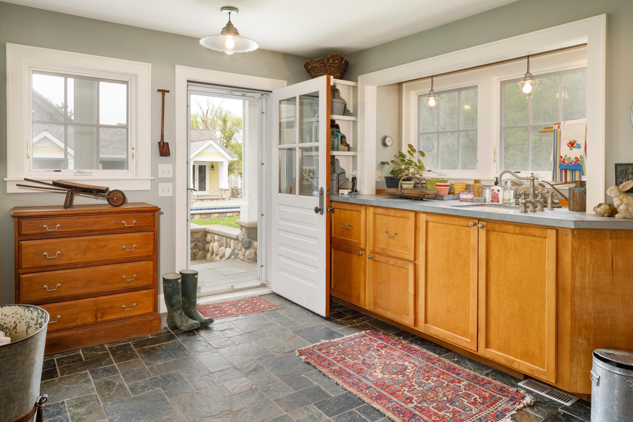 Charming and functional mudroom has direct access to primary residence, 4 stall garage, laundry room (one of two in the primary residence) power room, and courtyard.