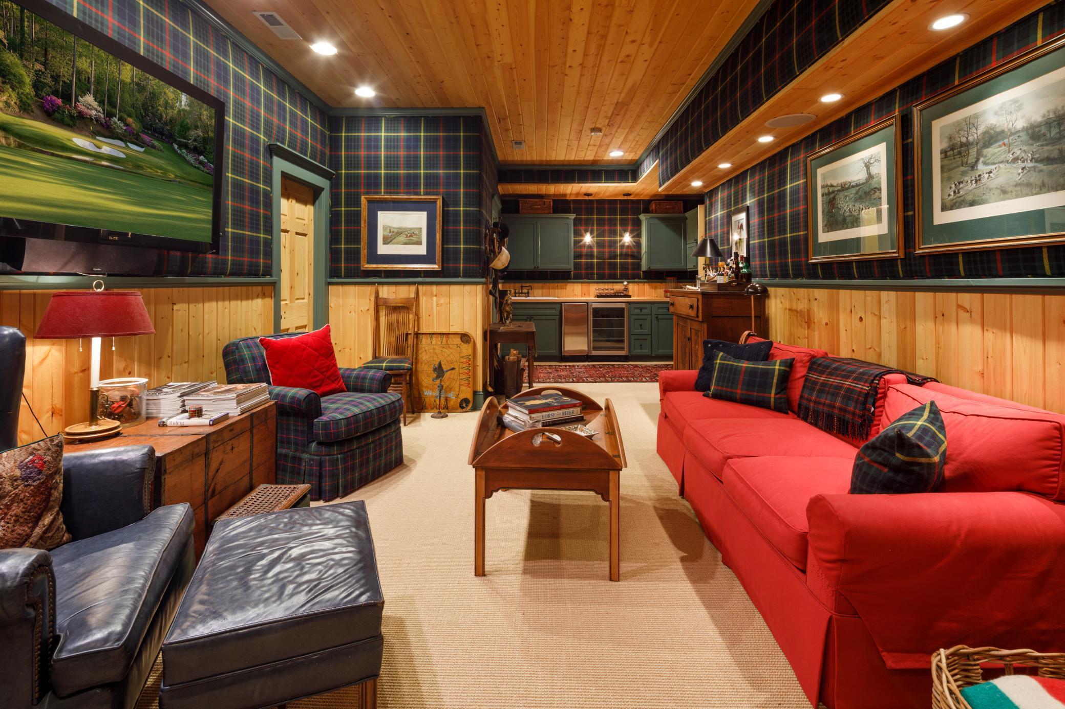 Ralph Lauren style home theater with wool plaid fabric wall coverings, wood paneled ceiling, wainscotting, surround sound, and a kitchenette/wet bar.