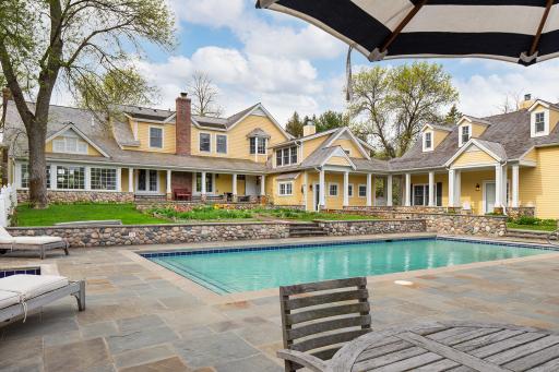 Picturesque English courtyard with gardens and pool.