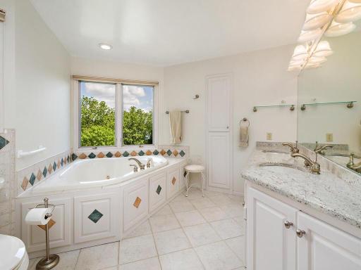 Master bath has separate shower, jacuzzi tub, double sinks, and linen cabinet
