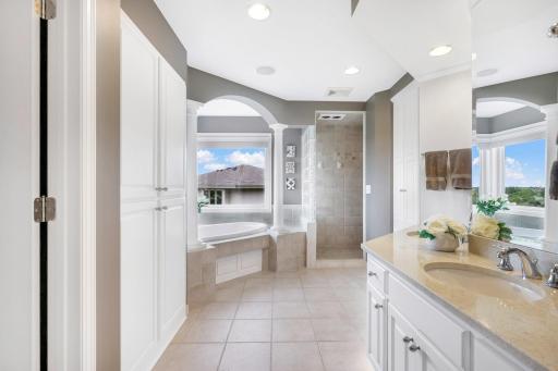 Private bath with dual sinks, deep jacuzzi tub and walk-in tile shower.