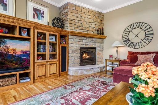 Relax within the comfortable great room featuring a gas fireplace with stone surround, and maple built-ins.