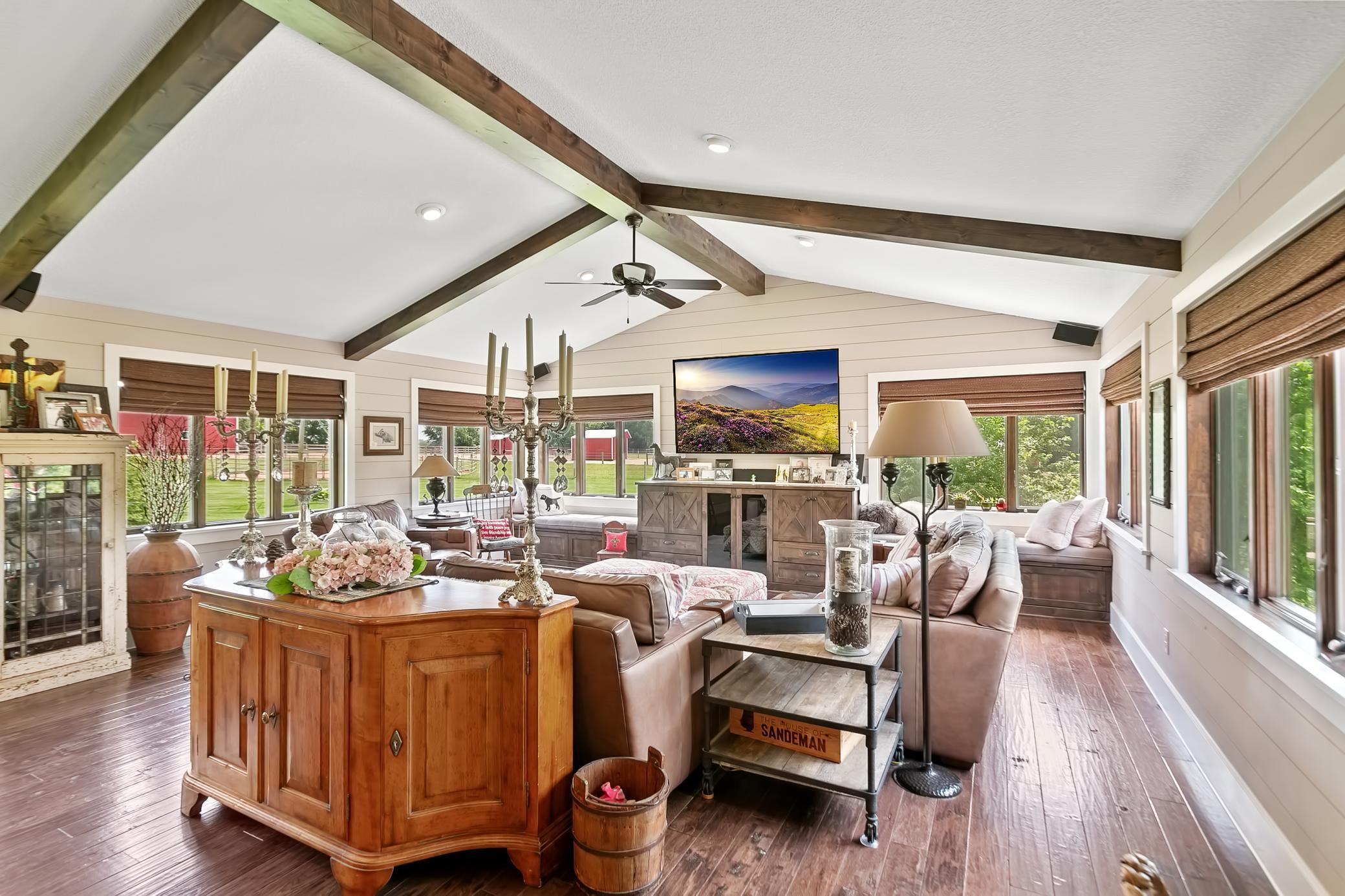 The great room has walls of glass on each side and features beautiful hardwood floors.