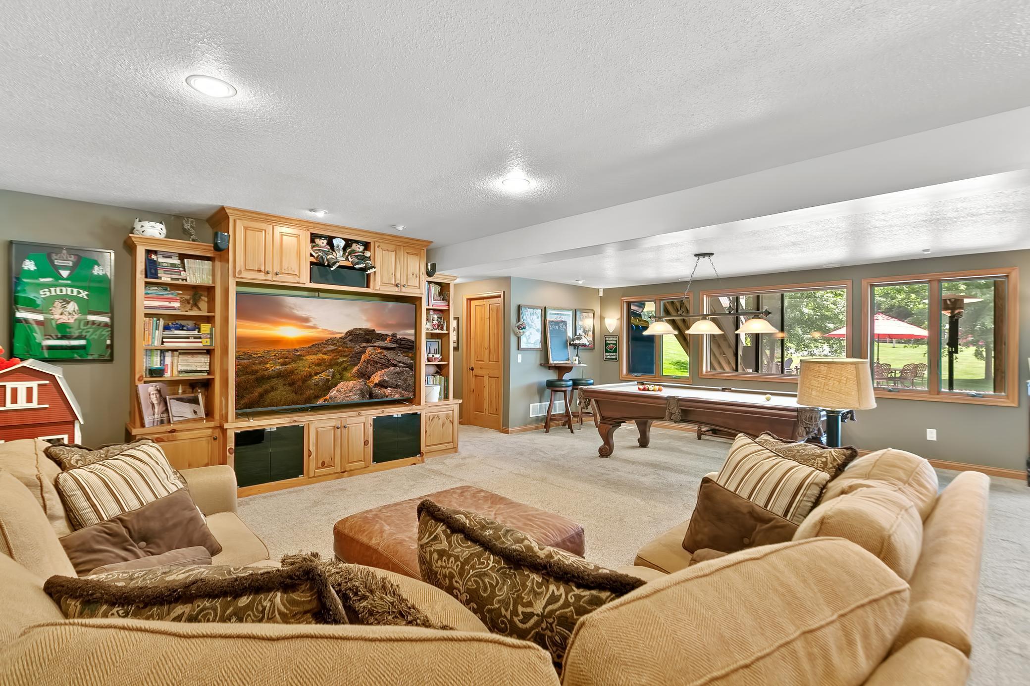 Spacious amusement room in the lower level with an abundance of storage and cabinetry.