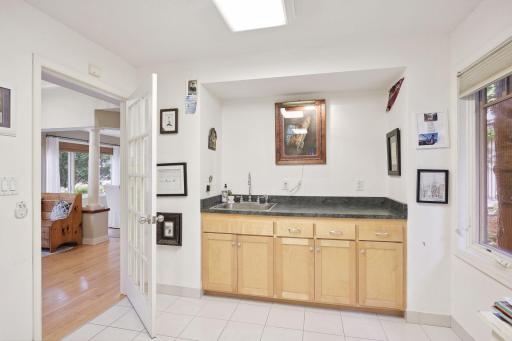 Entrance to the office and custom built-ins with sink offers extra storage.