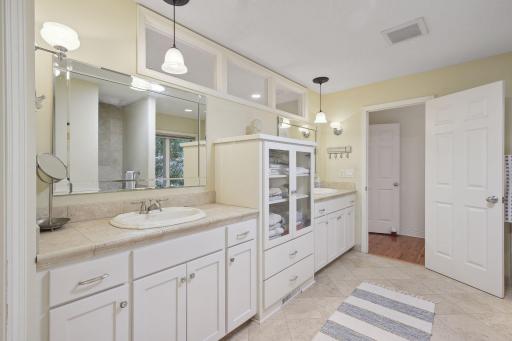 The Master bathroom offers separate owner vanities and additional cabinets for ample storage.