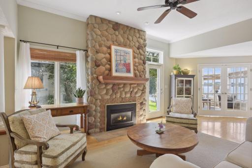 The living room offers 1 of 4 gas burning fireplaces and carries the River Rock inside. A ceiling fan and additional glass paneled door allows for natural daylight in.