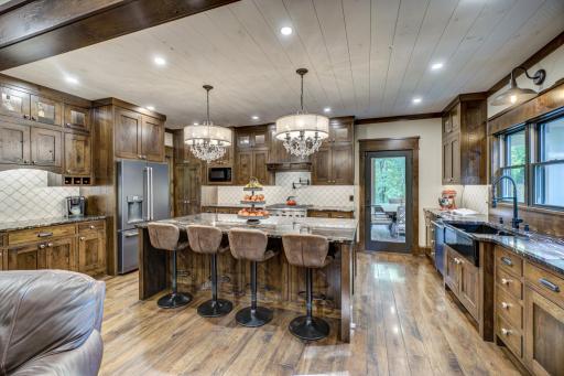 The open-concept gourmet kitchen features character-grade white oak cabinets, GE cafe series appliances, soft-close drawers, and a coffee/ wine bar among many other custom features!