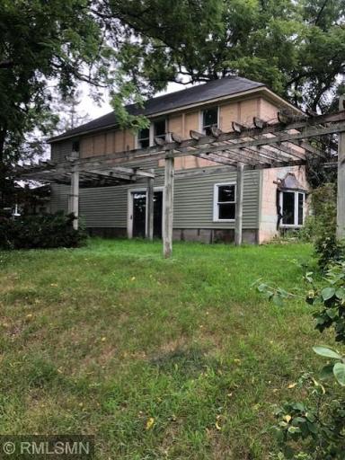 Large pergola in front of home. Vinyl siding remains partially completed