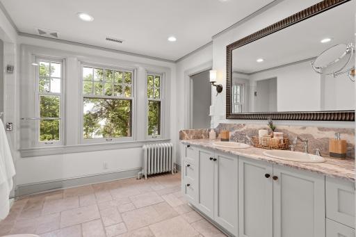 Large bathroom with dual sinks and fully tiled walk-in shower, and even a view of the lake!