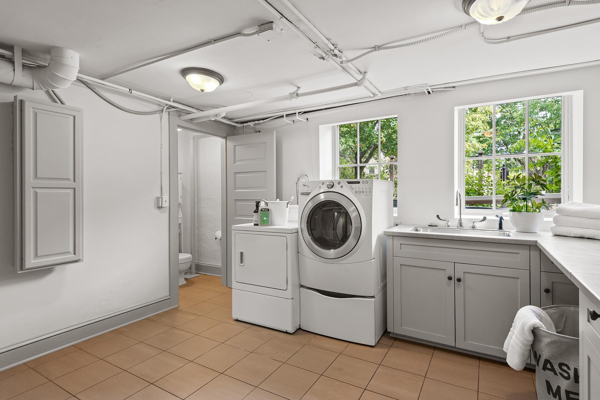 Lower level laundry too! Includes tile floor, tons of storage, expansive counter, and pull out ironing board.