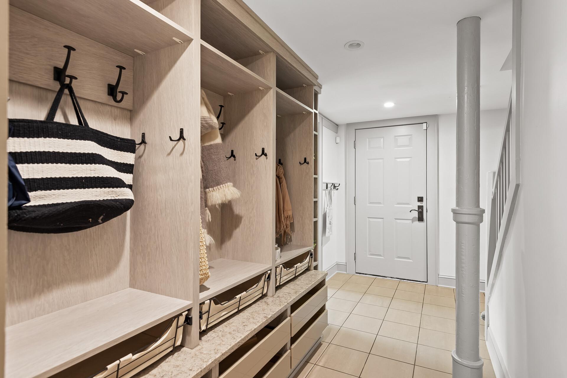 Custom mudroom with built-in lockers, drawers, hooks, and cubbies - so convenient! Access to the attached 2-car heated garage with electric car charger.