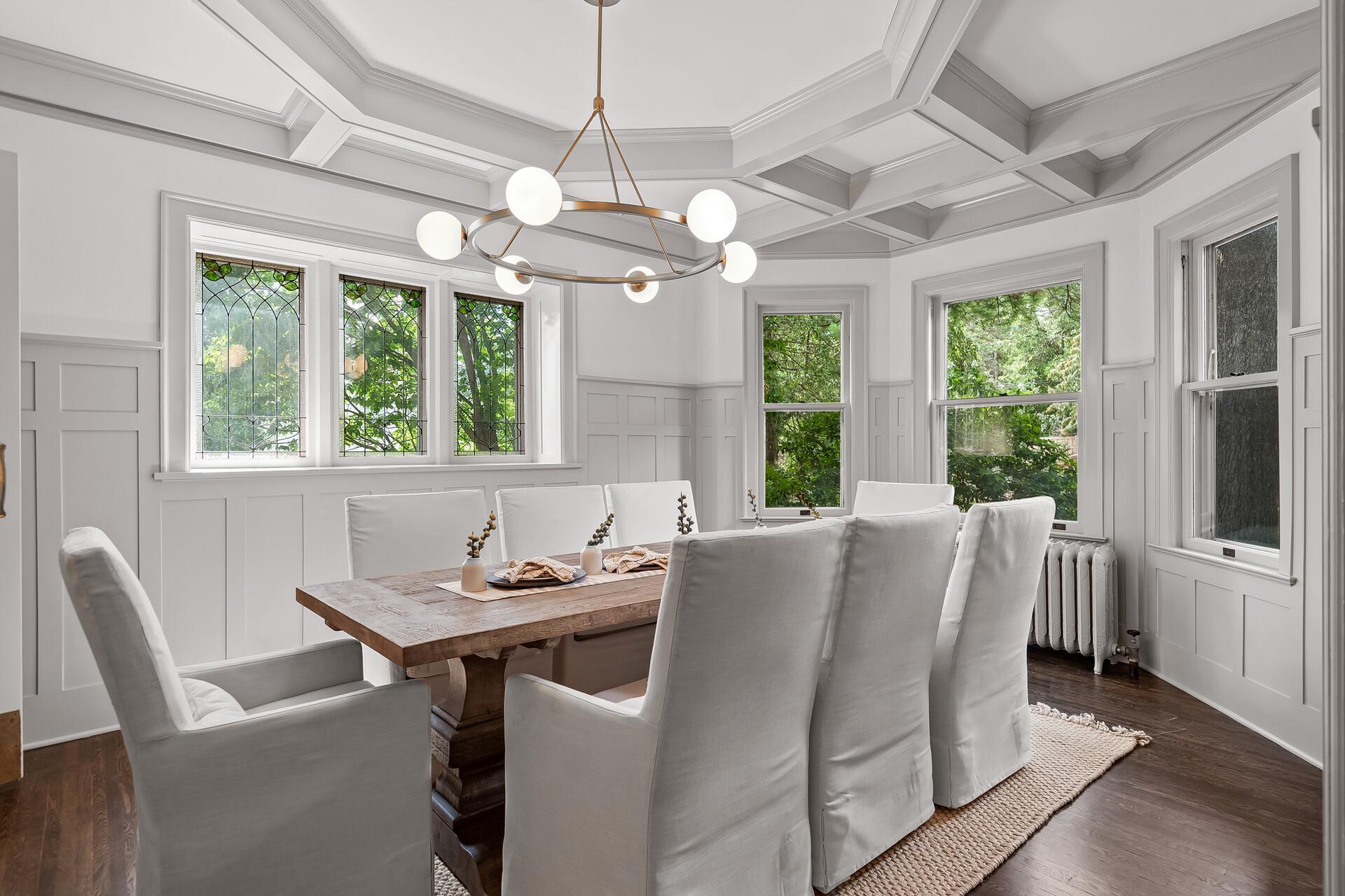 Formal dining room is spacious with plenty of room to host large gatherings, with a modern chandelier, gorgeous chair rail, and big sun-filled windows including beautiful stained glass windows.