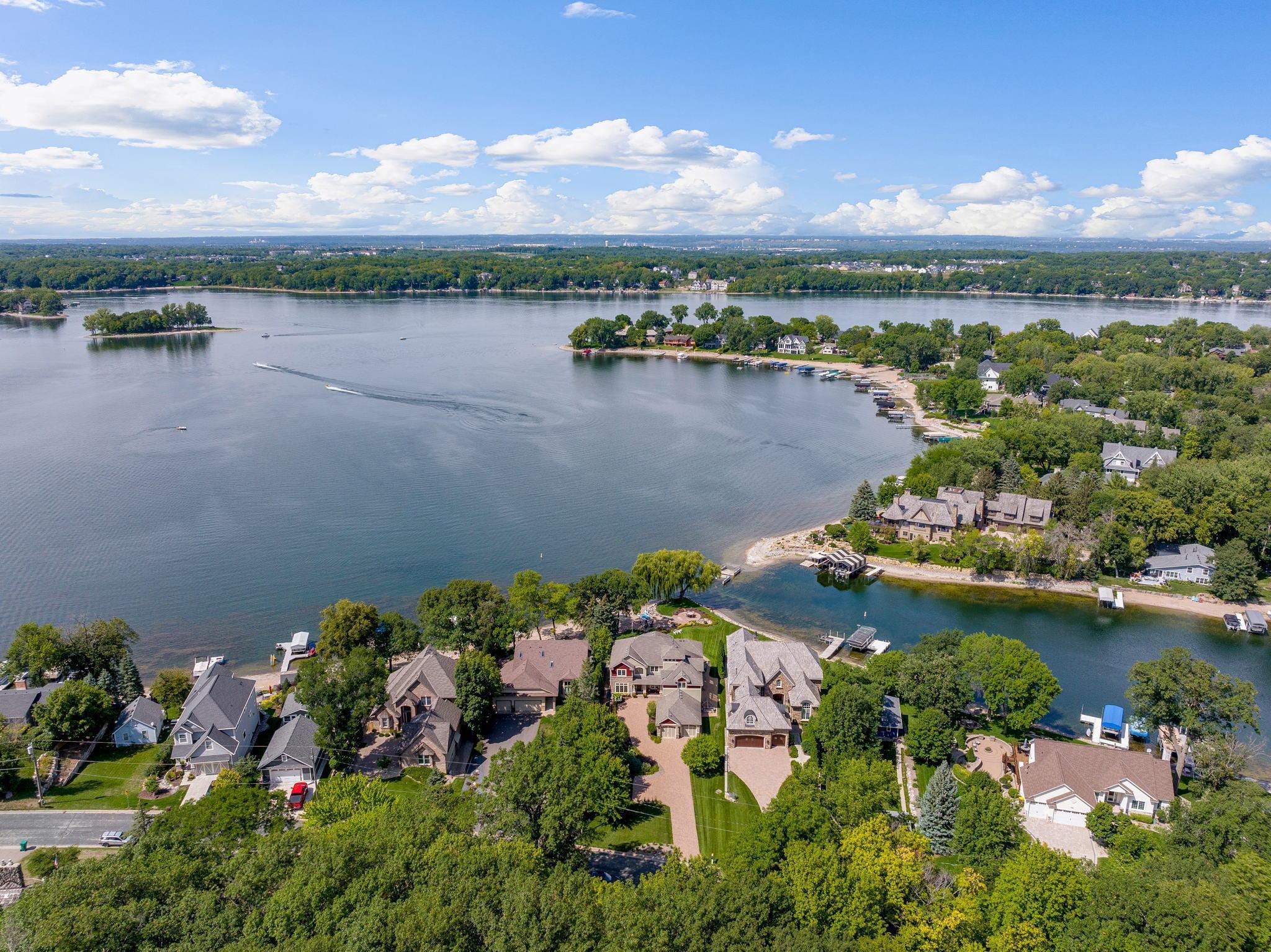 A true Storybook setting for this walkout 2 story on Lower Prior Lake with over 1/2 acre of gently sloping lakefront and picturesque landscape. This sanctuary shaped haven is lined with mature trees that engage the sunset filled skies.