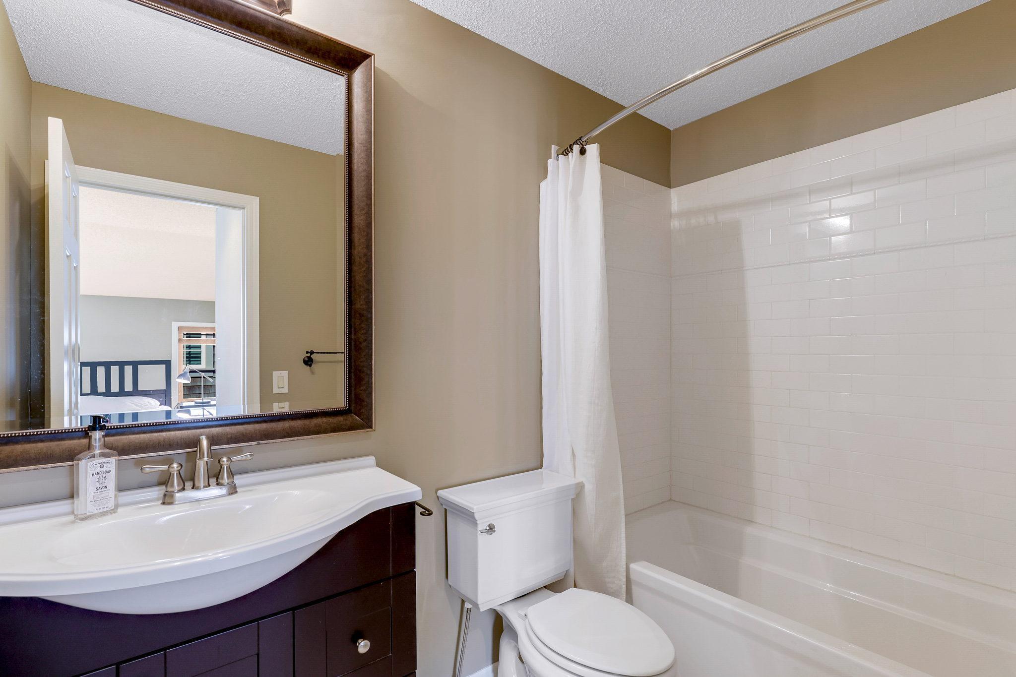 2nd Bedroom's private Full Bathroom features classic subway tile tub surround and mosaic tile flooring