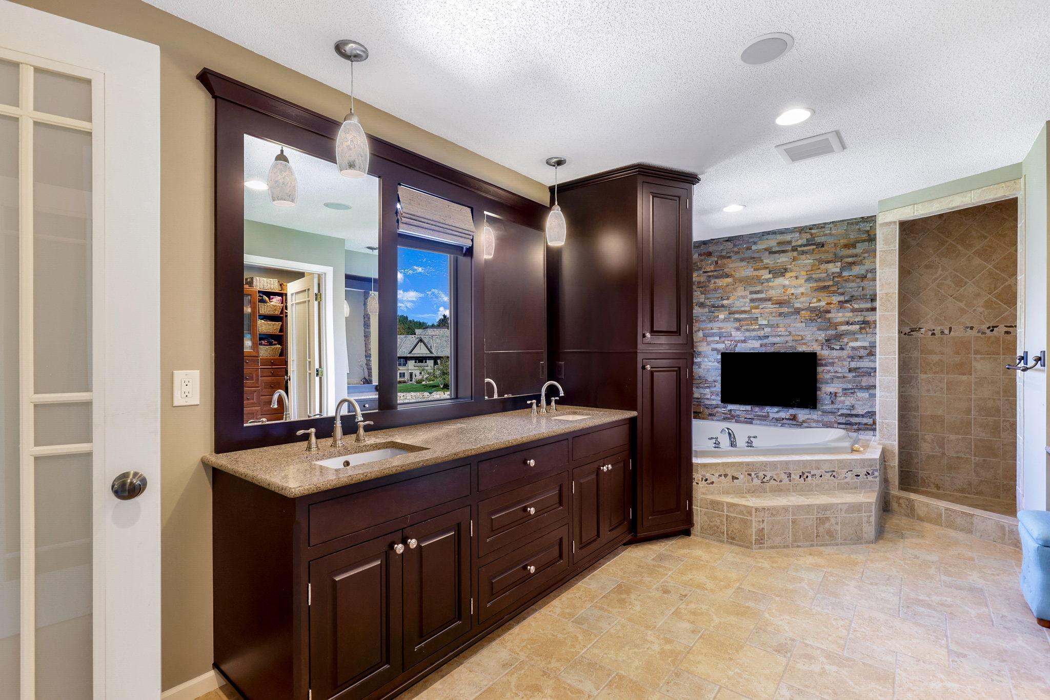 Master Bathroom features corner soaking tub, fireplace with natural stone surround, walk-in shower, alder vanity /linen tower and fantastic lake views!