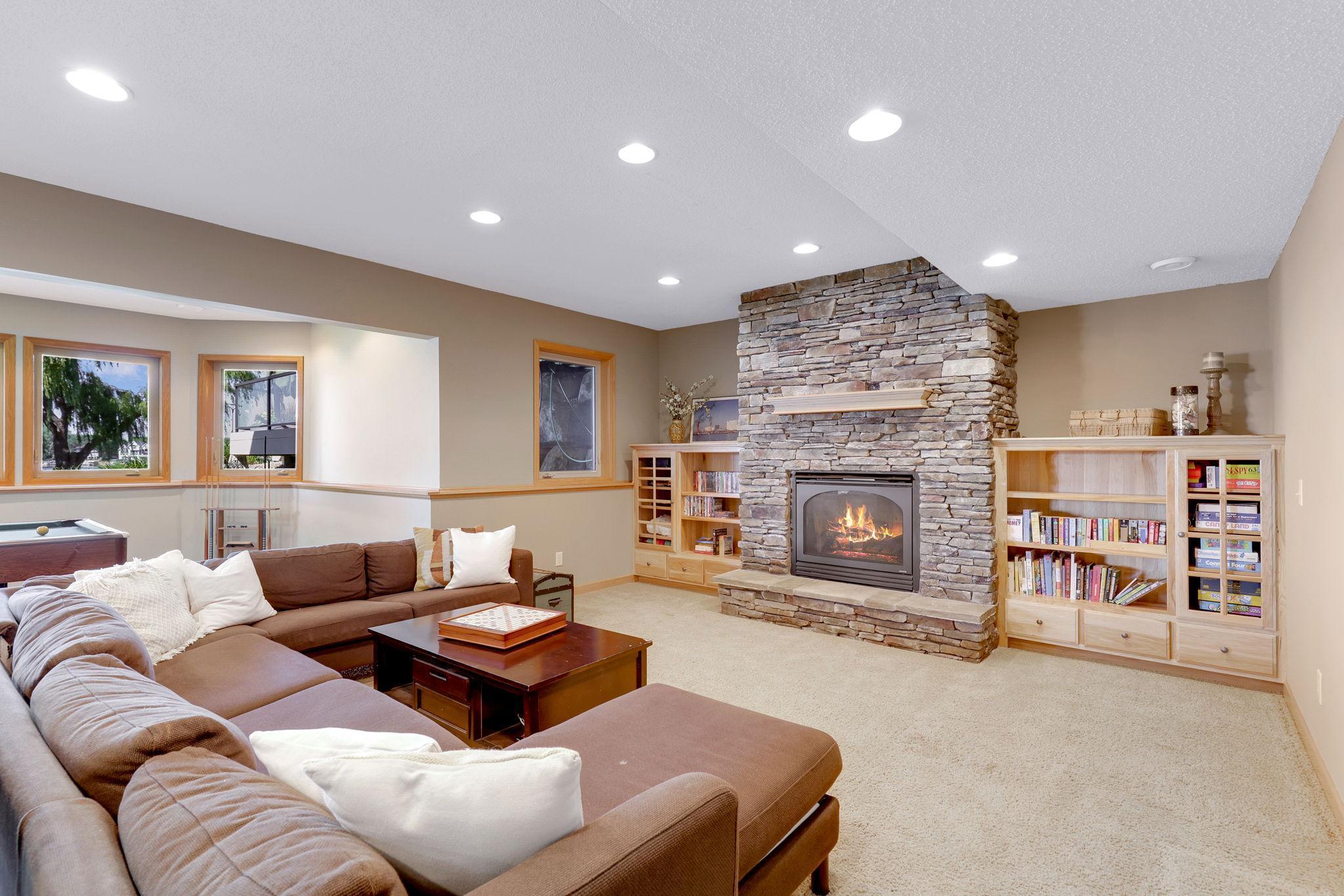 Lower level Family Room features a gas burning fireplace and cultured stone surround and raised hearth. Natural hickory built-in cabinets frame the fireplace nicely and provide great storage and display opportunities