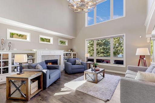 Great Room offers 2 Story ceilings with a stunning chandelier. Gas fireplace w/ slate tile surround and hearth Enameled built-in cabinets features glass doors and open display shelving