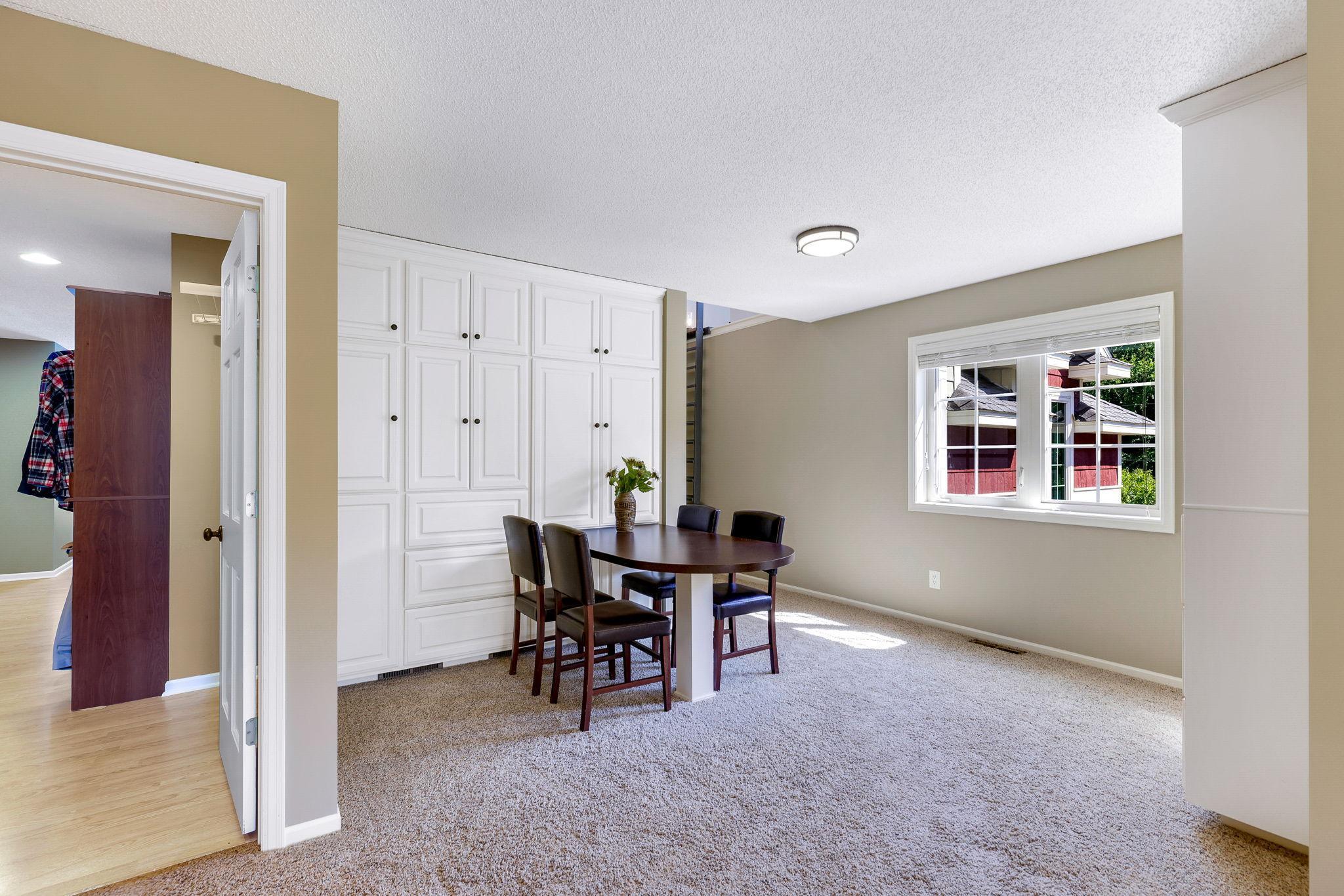Upper level loft boasts built-ins with workstation and open bookcase w/ storage