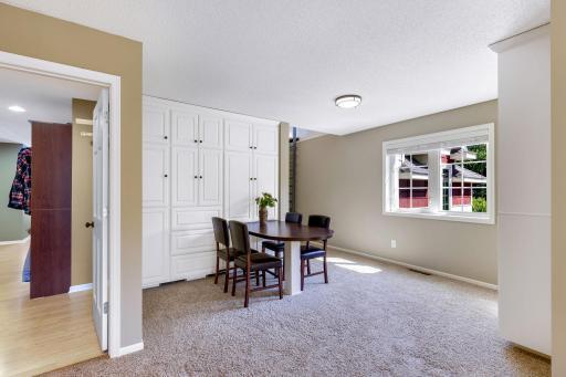 Upper level loft boasts built-ins with workstation and open bookcase w/ storage