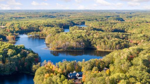 Property areal with view of the main lodge, carriage house and surrounding lakes
