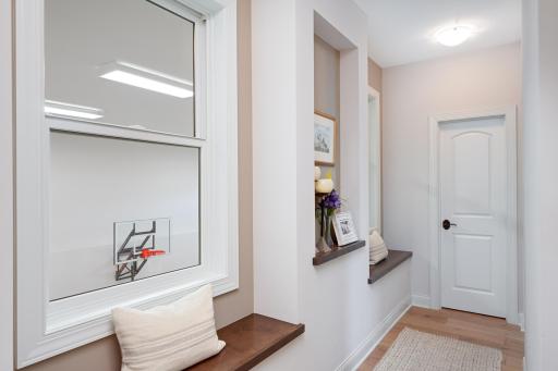 Side hallway overlooking INDOOR sport court and leads to large walk in pantry off kitchen