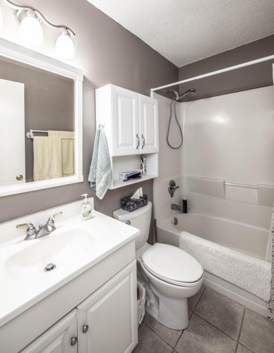 Light and bright full bathroom with tile floors.