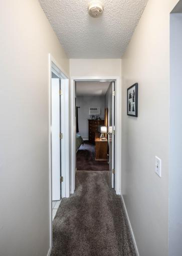 Hallway to full bathroom and into primary bedroom