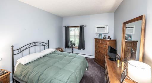 Primary bedroom has tall ceilings, its own wall unit AC (newer - bought in 2021) and overlooks the backyard green space. Tons of space for multiple furniture pieces.