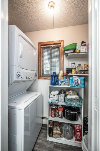 Laundry with stackable w/d. On opposite wall from the w/d is shelving perfect for pantry. Plus a little window to provide natural light.