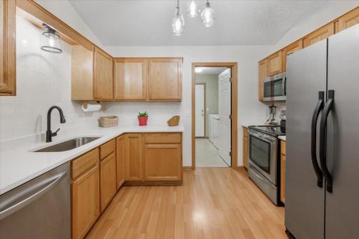The light and bright kitchen has stainless steel appliances and new quartz countertops, sink and faucet.