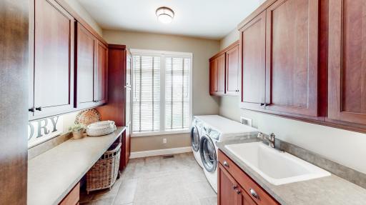 Laundry room on main-level with ceramic tiled in-floor heat. Vinyl counter top, cherry cabinetry, & Kohler sink/faucets.