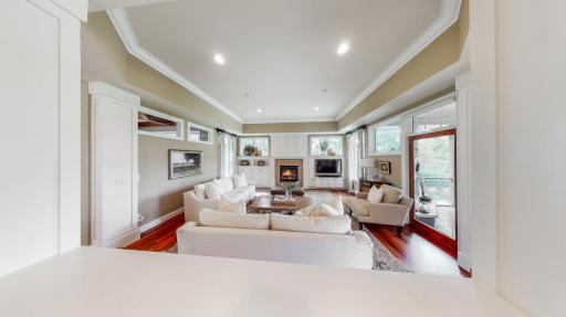 A gas fireplace with travertine surround. Marvin windows with remote controlled Hunter Douglas window coverings