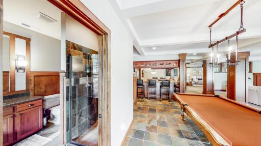 Billiards room & 3/4 bathroom with slate tile flooring that features a walk-in shower
