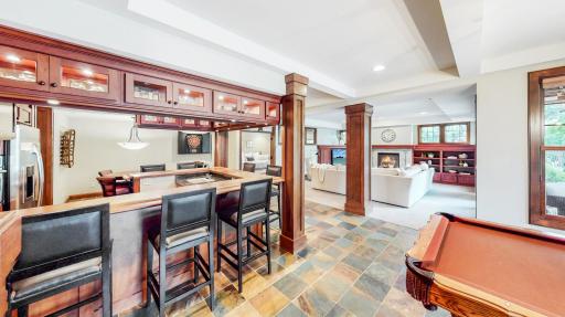 Wet bar with cherry wood with a full view of indoor & outdoor entertainment/recreation areas.