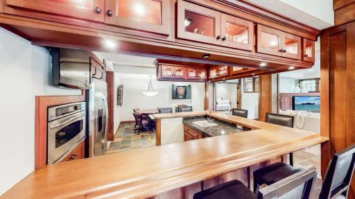 Cherry hardwood cabinetry with lighting underneath & inside overhead cabinets