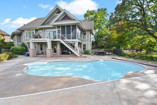 Entertainment area behind home with pool, patio, deck & hot tub