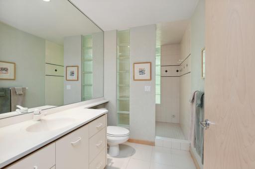 Adjacent is the hallway 3/4 bathroom with ceramic tile surround and glass block entrance.