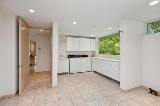 Adjacent areas host the catering quarters, laundry area with full picture windows, storage/mud room area with built-in cabinets and boot bench, and access to the 4-car heated and sheet rocked garage.