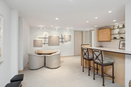 When the office day has come to an end, mosey over to the sleek custom wet bar with ceramic tile floors and overhead cabinets and shelving.