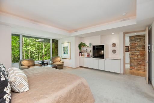 The ceilings boast a box vault with mood lighting and surrounding recessed lights. Tucked in the wall is a book and tv shelf.