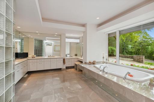 There are double vanities with abundant storage, heated floors, walls of mirrors and a separate commode room.