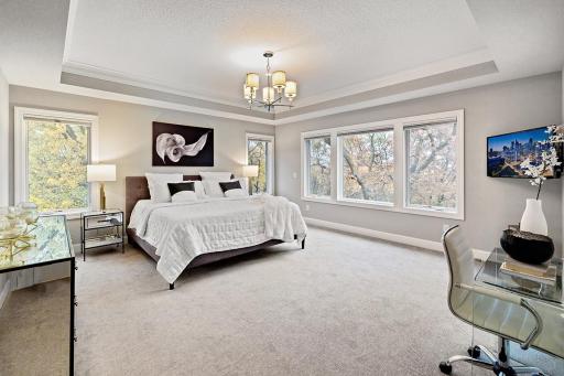 Generous primary suite with tray ceiling and big, walk-in closet