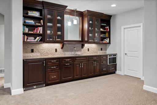 Lower level walk up wet bar with refrigerator and microwave